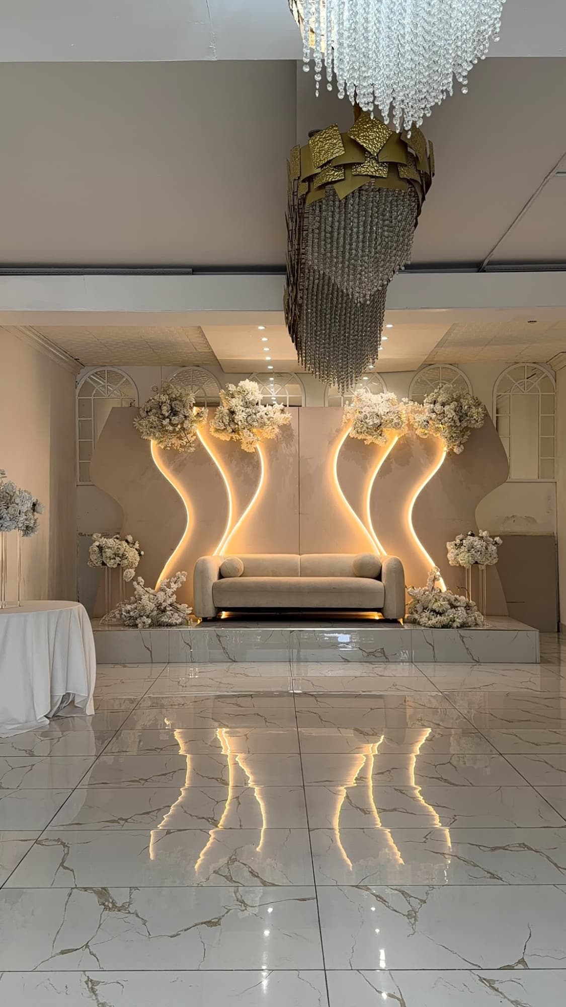 The stage and crystal chandelier reflected in the polished marble floor